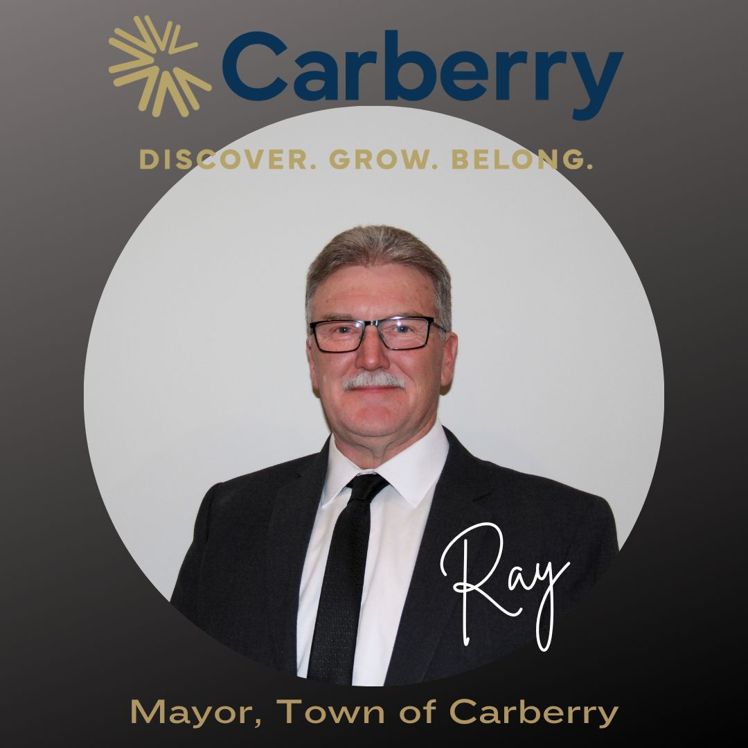Headshot of Mayor Ray Muirhead. There is a man wearing a suit and glasses in front of a blank background.